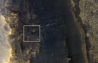 NASA's Opportunity rover appears as a small blip in this image of the dusty Martian surface.