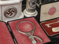 The head-measuring device, an ornamental key, and a steel cross pin sit in their cases