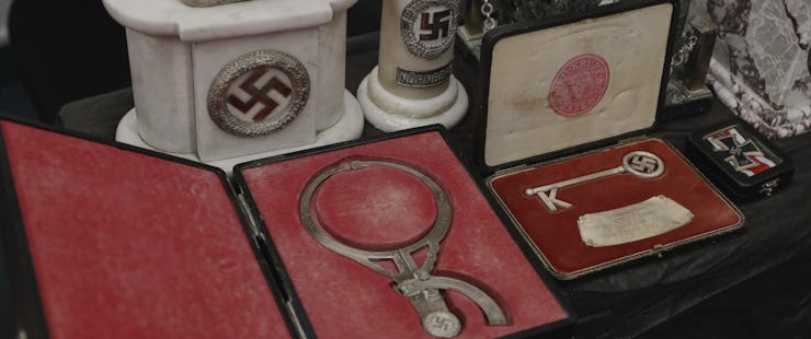 The head-measuring device, an ornamental key, and a steel cross pin sit in their cases