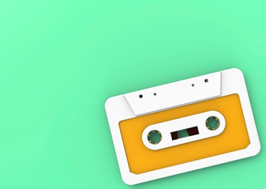 White and orange music cassette tape on a green background