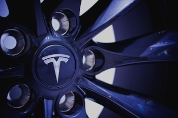 A closeup of a Tesla wheel with the logo in the middle