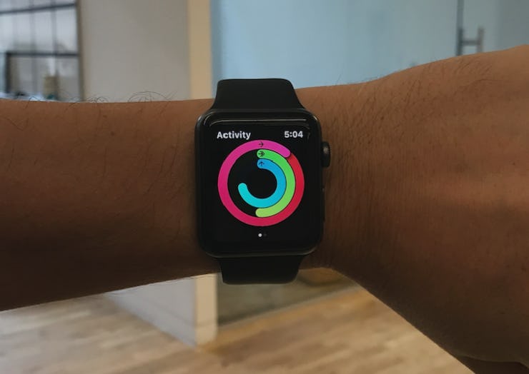A man using a smartwatch with a walking goal that ends with '0.'