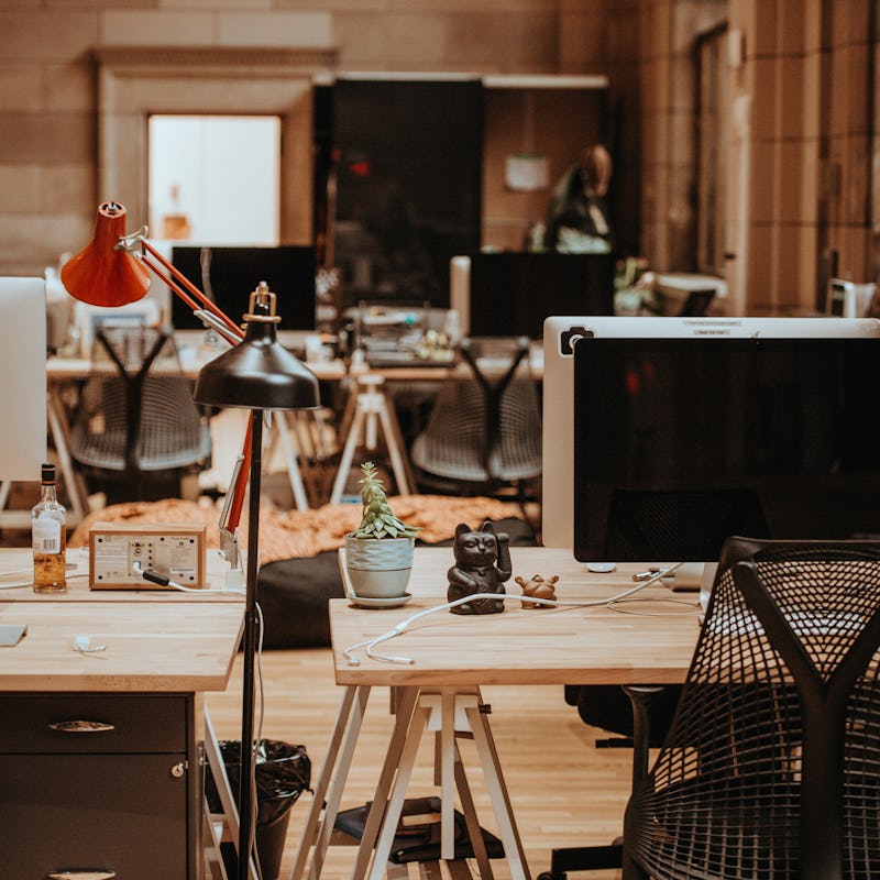 Tidy office containing wooden tables with different decorations and computers