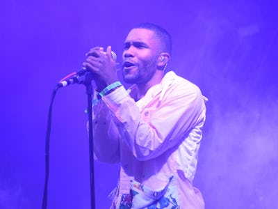 Frank Ocean performing live on stage bathed in a purple light