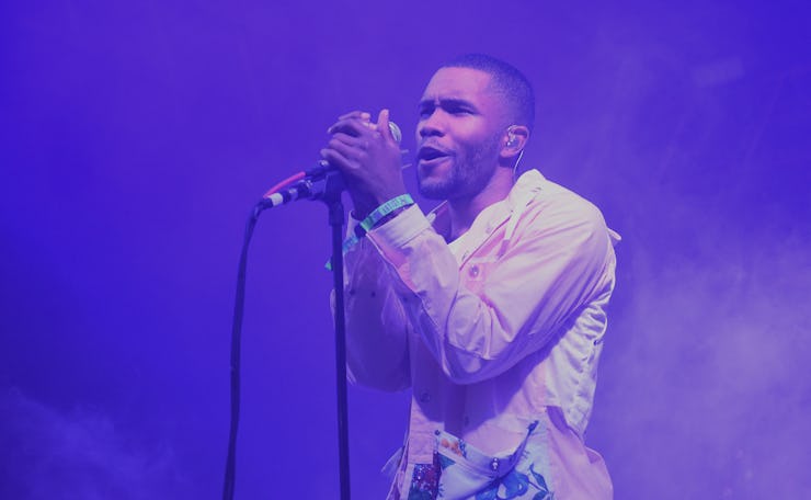 Frank Ocean performing live on stage bathed in a purple light