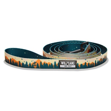 A dog leash with mountains and green trees. 