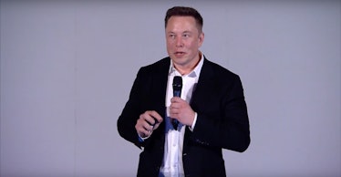 Elon Musk holding a microphone during his speech