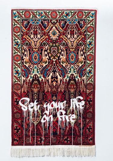 Red Faig Ahmed carpet with "set your life on fire" white text