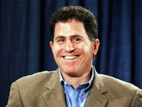 Michael Dell in a blue shirt and a beige blazer smiling 