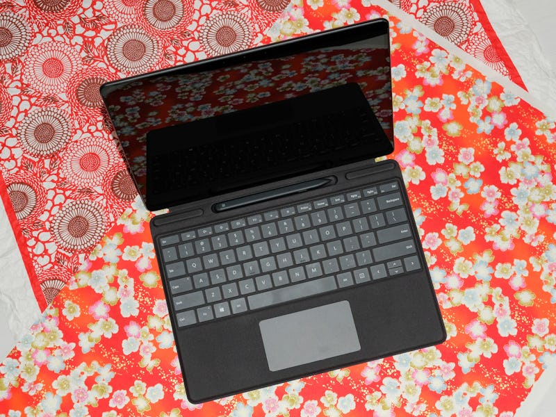 Microsoft Surface Pro X sitting on multiple patterned table cloths