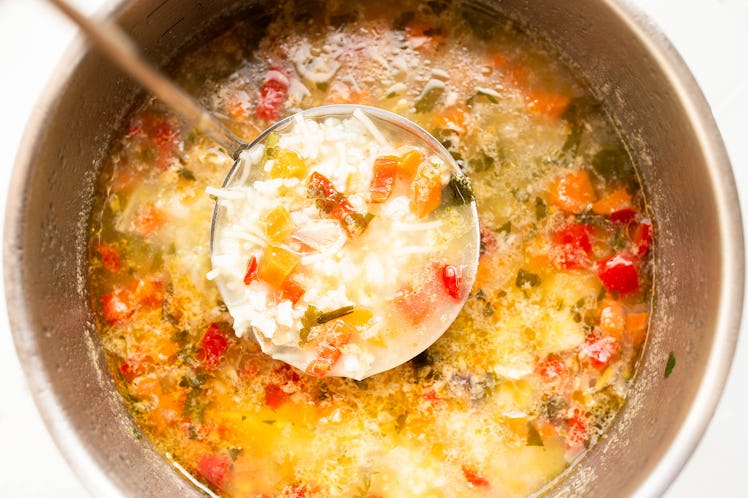 Rice chicken vegetable soup in saucepan with spoon