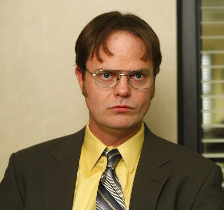 Dwight Schrute from "Office" series in a formal suit with a yellow shirt
