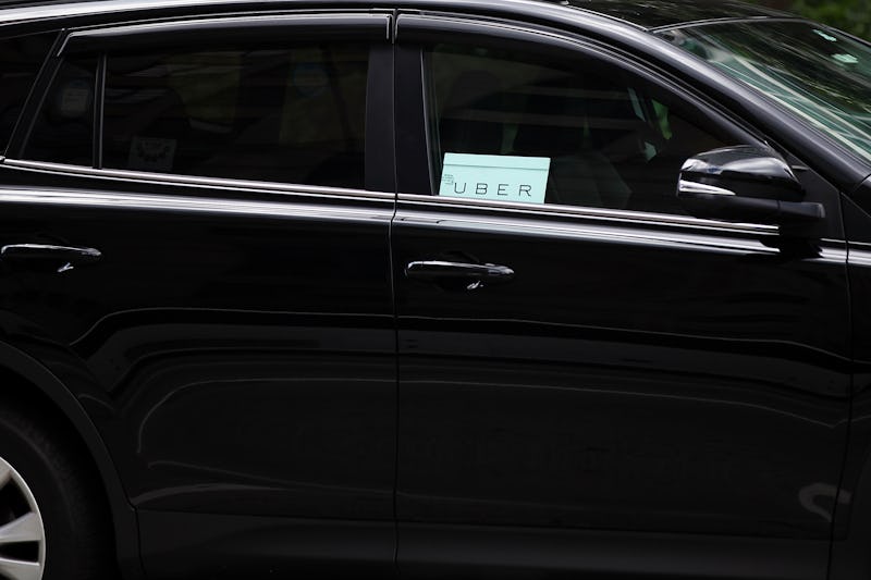 A black car with an Uber sign visible at the window