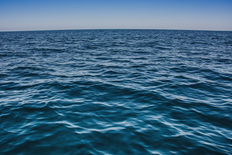 A blue surface level of an ocean and blue sky