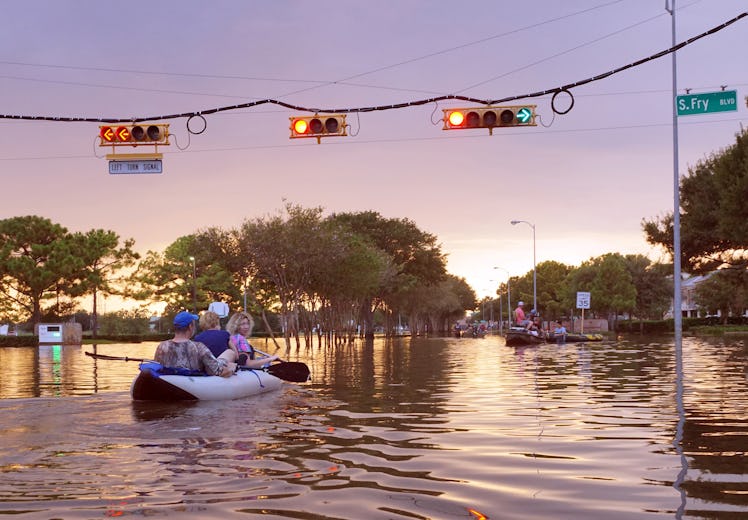 working traffic lights over flooded Houston streets and boats with people at sunset 