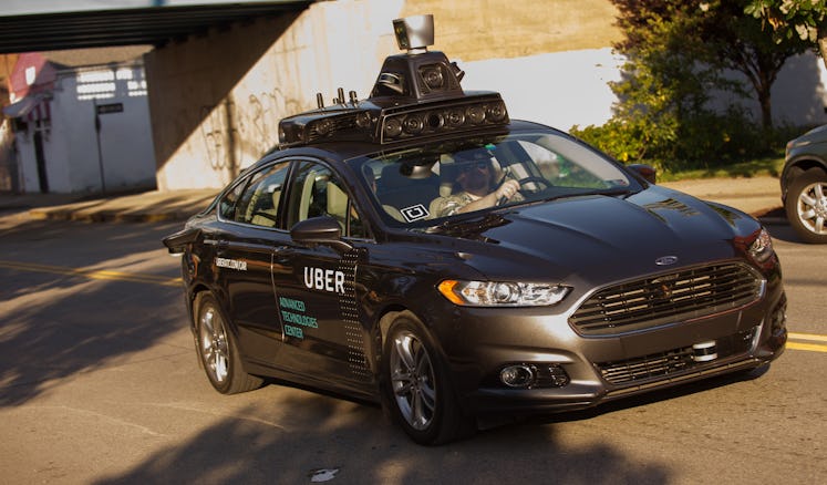 An Uber driverless Ford Fusion driving down Pittsburgh's Smallman Street