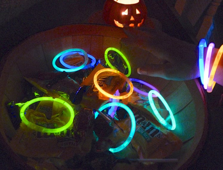 A lot of differently colored circle glowsticks shining in dark