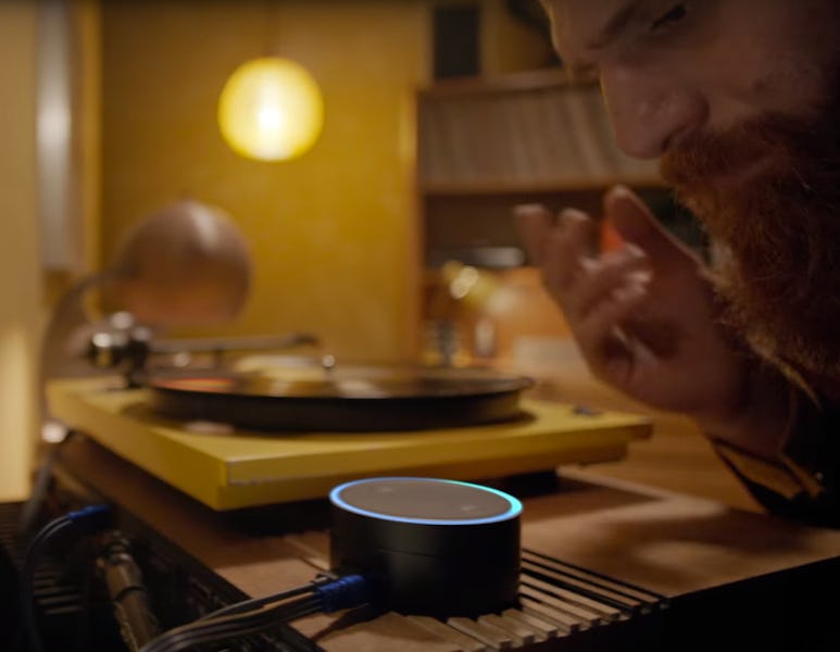 A closeup of a man speaking into an Alexa-enabled echo dot 
