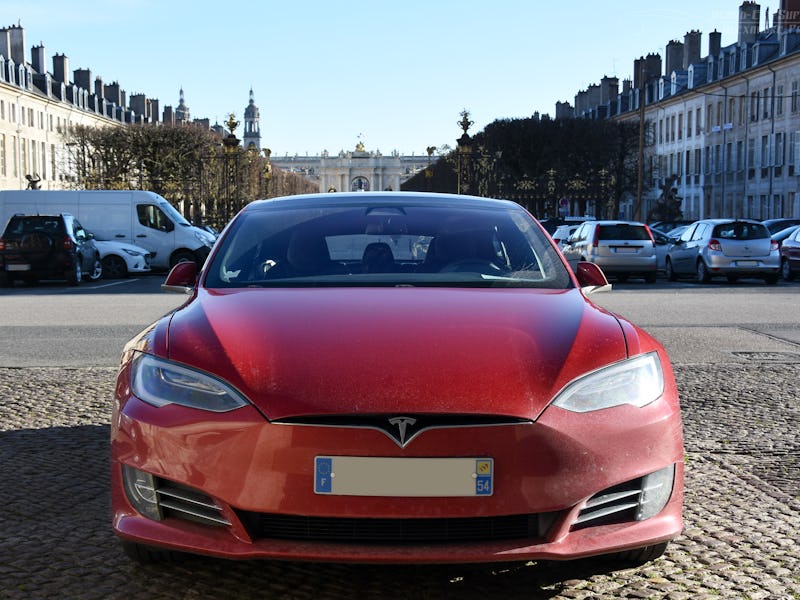 The front of a red Tesla electric car on a parking lot