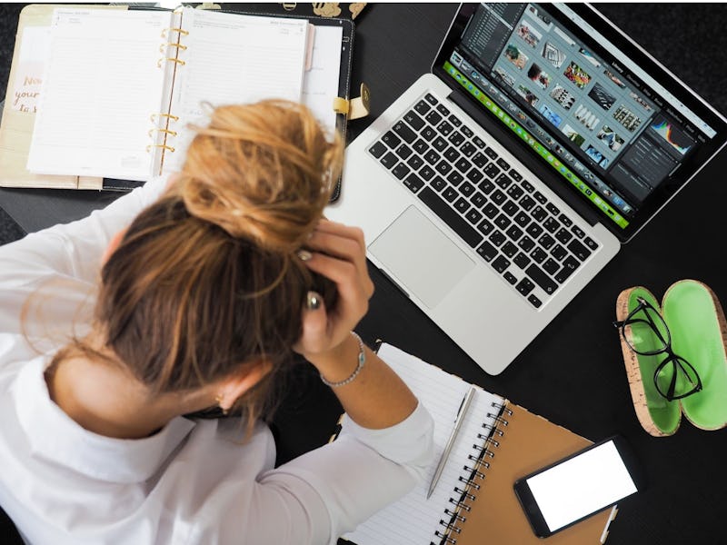 A woman using one of Apple's top-rated apps on her laptop and a book next to it