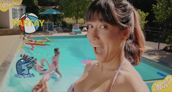 A woman taking a selfie with a swimming pool in the background for the Facebook Messenger Snapchat-l...