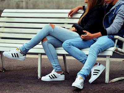 A couple sitting on a white bench while hugging