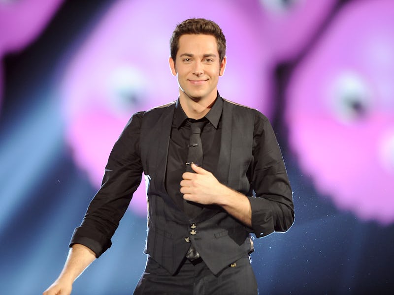 Zachary Levi wearing a black shirt and a black vest over it