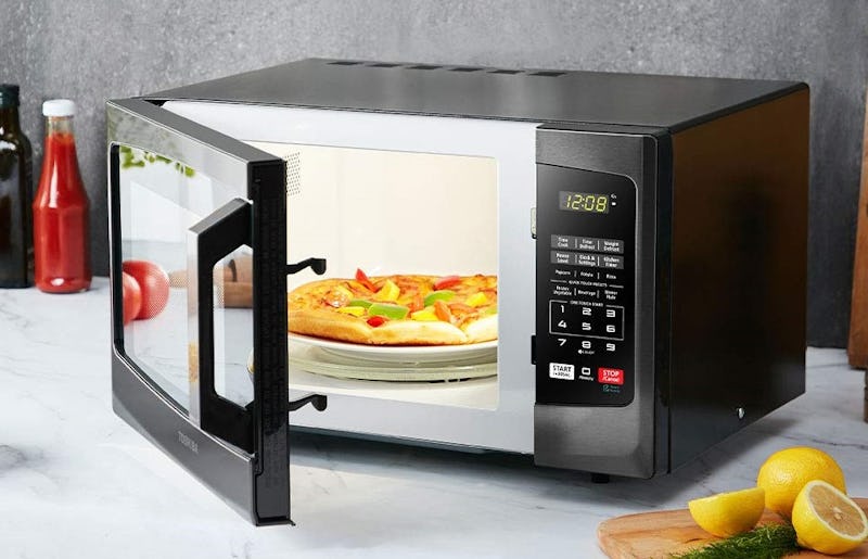The Toshiba EM925A5A-BS Microwave Oven slightly open with a pizza in it.