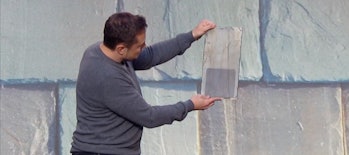 Elon Musk holding a slate solar tile.