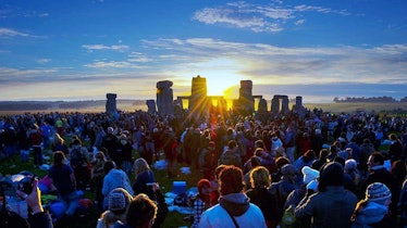 Revelers watch the Solstice Sun rise over Stonehenge Heel Stone
