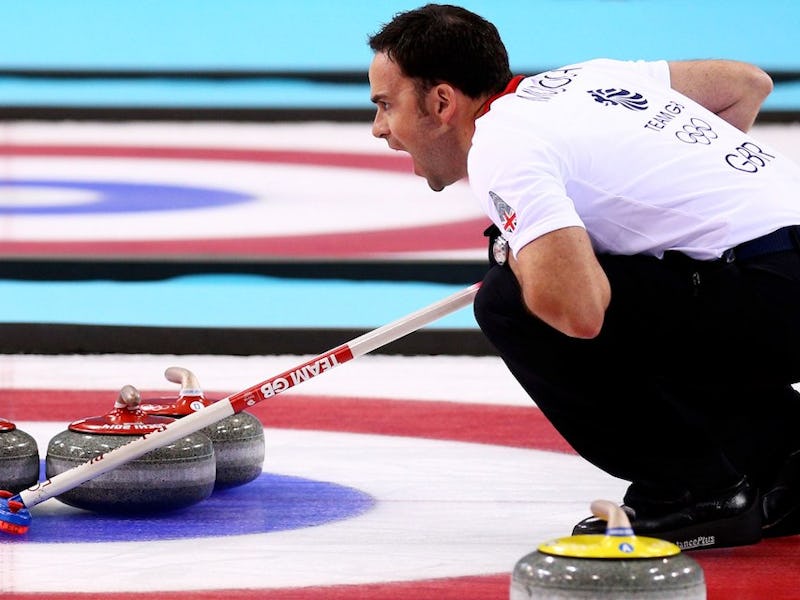 A member of the Canadian curling team, crouching while playing
