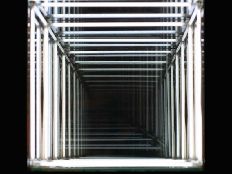 A hall with LED lights on the ceiling and walls making a recursive effect
