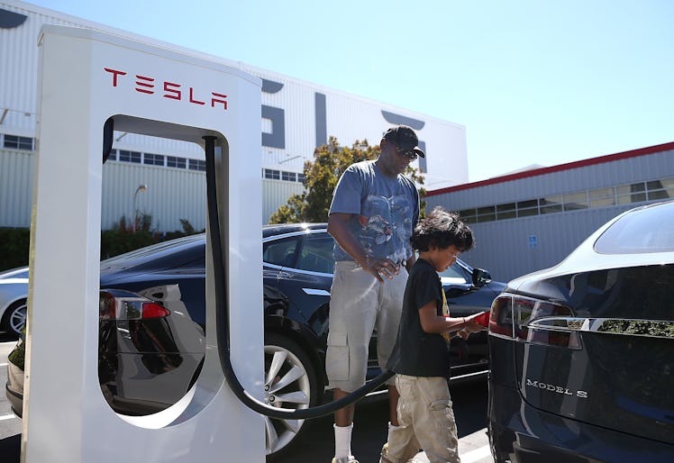 FREMONT, CA - AUGUST 16: Jinyao Desandies (R) and Dandre Desandies (L) plug the Tesla Supercharger i...