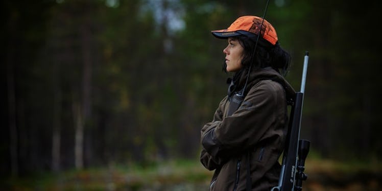 A woman with an orange cap standing in the middle of nature