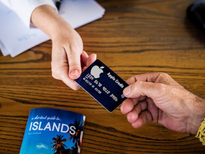 A man taking the black Apple Credit card from a woman's hand