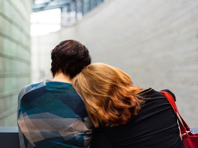 A grieving girl crying on the shoulder of a boy