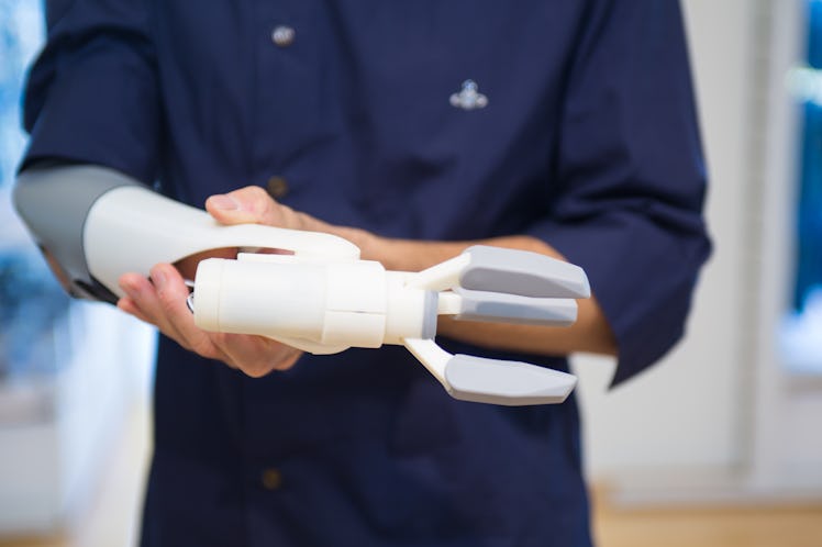 A potential user tenses his muscles to open the pinch mechanism on this 3D printed prosthetic arm in...