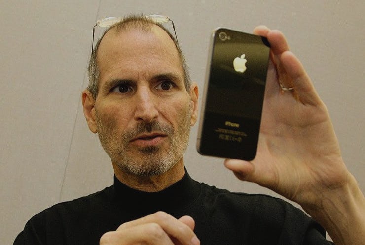 Steve Jobs holding up the iPhone 4 in black 