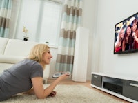 A woman changing channels on her smart TV