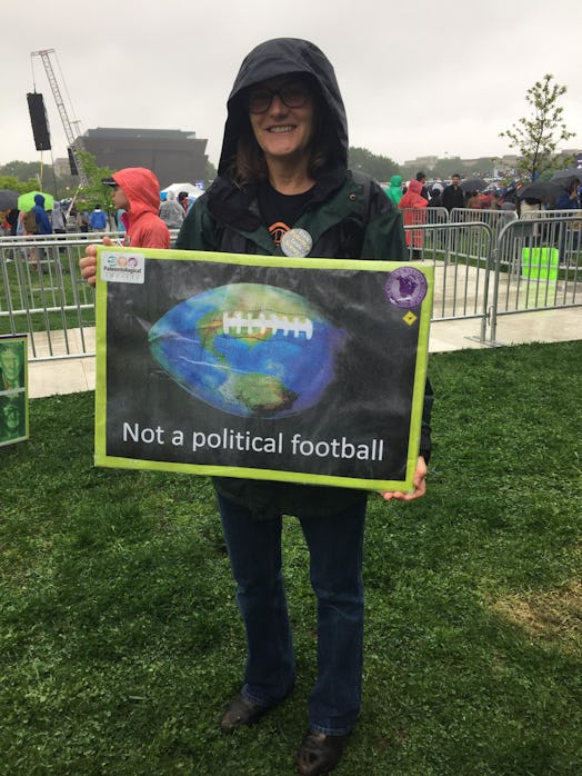 A man holding a poster with an Earth photo and "not a political football" text