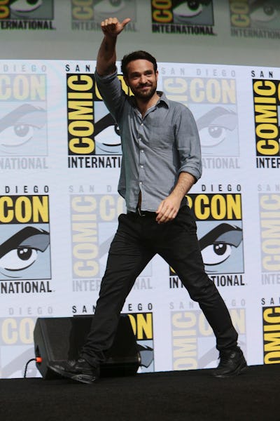Charlie Cox waving to fans while walking at the Comic-Con event