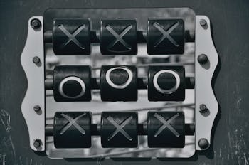 A metal square-shaped Tic-Tac-Toe box game.