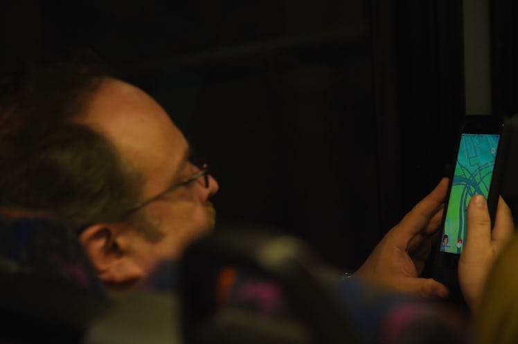 An adult man playing a video game on his phone
