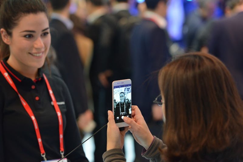 A woman taking a picture of another woman during the Mobile World Congress 2018 in Barcelona
