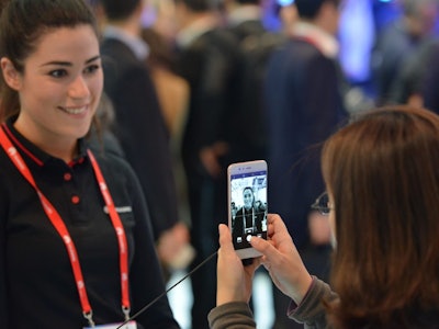 A woman taking a picture of another woman during the Mobile World Congress 2018 in Barcelona
