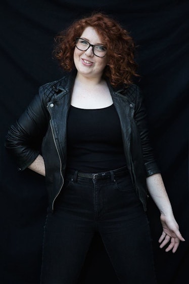 A curly hair girl smiling and posing for a picture wearing a black outfit