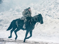 Jon Snow riding a horse through a snow storm in Game of Thrones