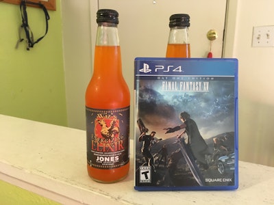 Two bottles of orange Wiz soda and the video game Final Fantasy XV