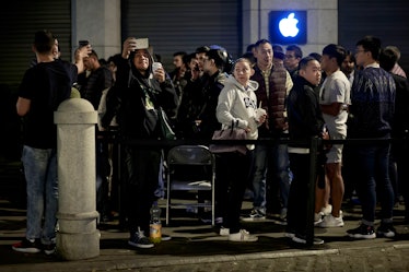 Customers take pictures with their mobile phones as they queue at Puerta del Sol Apple Store before ...
