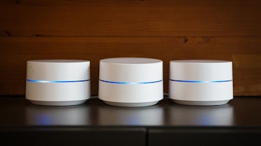 Three Google Wifi Home routers on a black table